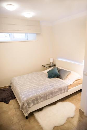 1 dormitorio con cama y alfombra blanca en Stay in Kaunas - Free Parking, en Kaunas