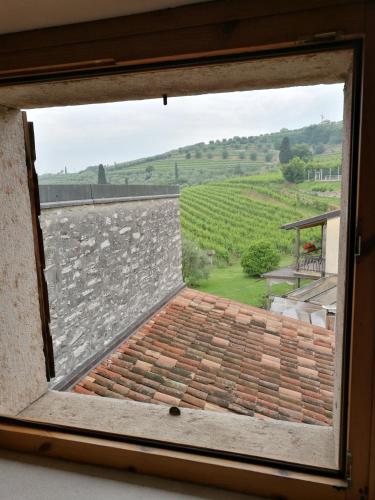 a window with a view of a stone wall at Costa degli Ulivi in Fumane