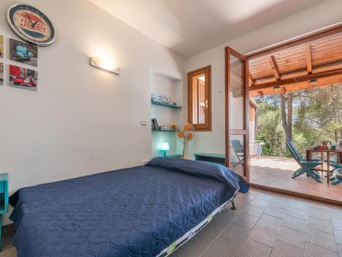 a bedroom with a blue bed and a patio at Sardinia SPA Apartment in Geremèas