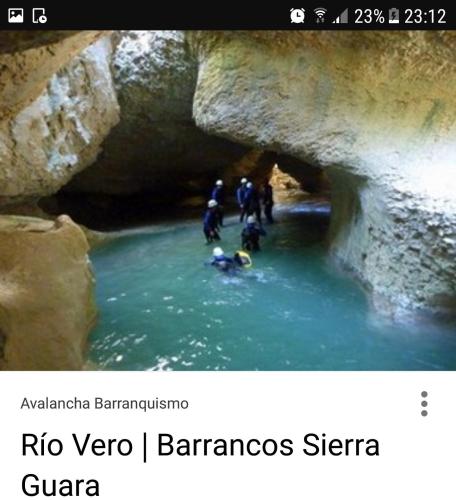 a group of people in a cave in the water at Carmen De Arnas in Colungo