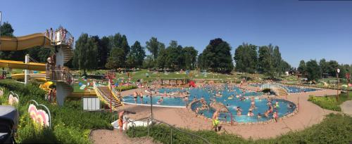 a water park with a large pool with people in it at Hotel BB Bahnhof Bertsdorf in Olbersdorf