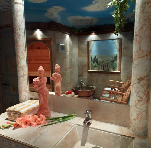 a bathroom with a sink with two statues on the counter at Hotel Berghof in Biersdorf