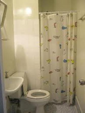 a bathroom with a toilet and a shower curtain at IMPACT Don Mueang Bangkok Guest House in Nonthaburi