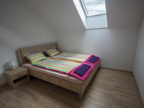 a small bed in a room with a window at Apartment Marjetka in Žirovnica