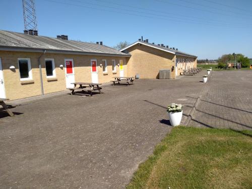 un gran aparcamiento con bancos y un edificio en Motel Lyren en Padborg