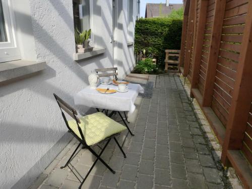 einen Tisch und Stühle an der Seite eines Gebäudes in der Unterkunft Ferienwohnung an der Kimbach 1 in Bad König