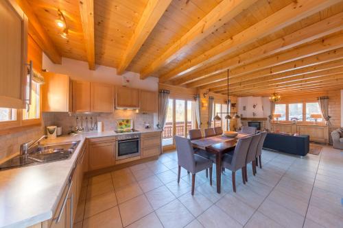 a kitchen with a wooden ceiling and a table and chairs at Chalet Le Papillon - Calm, sunny, spacious in Nendaz