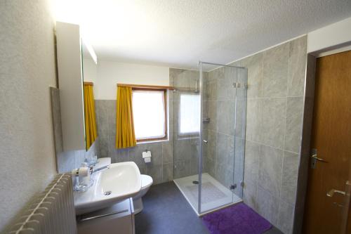 a bathroom with a sink and a shower at Ferienhaus Wanner in Splügen