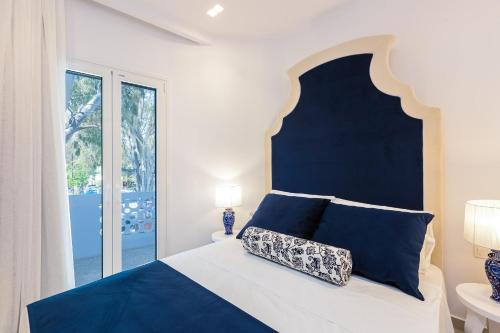 a bedroom with a blue and white bed and a window at Georgioupolis Plaza Suites in Georgioupolis