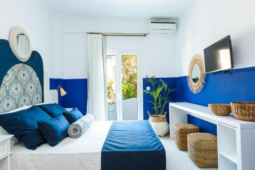 a blue and white bedroom with a bed and a window at Georgioupolis Plaza Suites in Georgioupolis