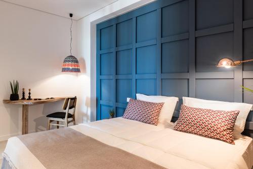 a bedroom with a blue headboard and a bed with pillows at Blue Island Luxury Apartment in Kato Daratso