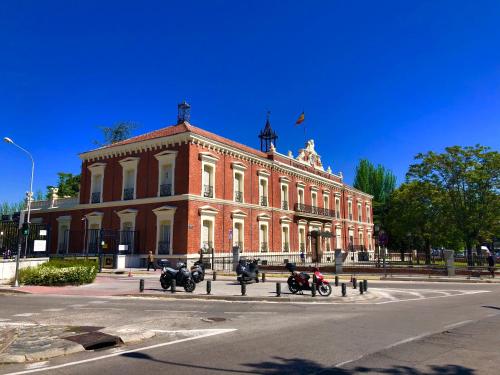un gran edificio de ladrillo con motocicletas estacionadas frente a él en Hostal Granado, en Madrid