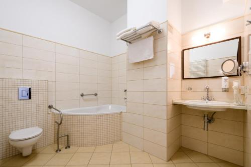 a bathroom with a tub and a toilet and a sink at Hotel Sitarska in Biłgoraj