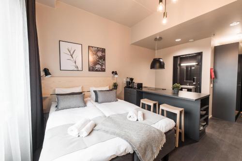 two beds in a room with a desk and a counter at Forenom Aparthotel Vantaa Tikkurila in Vantaa