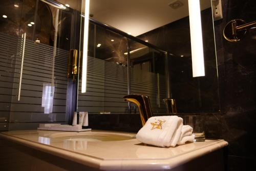 a bathroom with a sink with towels and a mirror at Lumiere Des Etoile in Kuwait