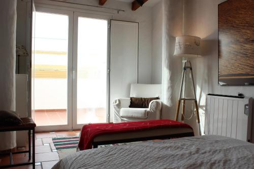 タリファにあるÁtico Castilloのベッドルーム1室(ベッド1台、椅子、窓付)