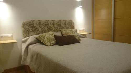um quarto com uma cama grande com duas almofadas em Casa de George em Málaga