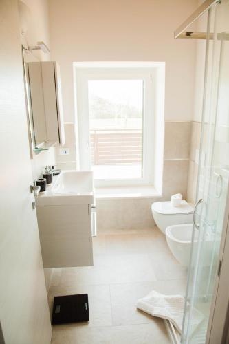 a bathroom with a sink and a toilet and a window at Gate To Verona in Verona