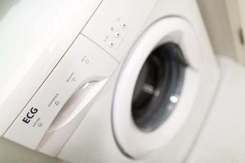 a white washing machine sitting in a room at Golden Apartments Rezidence Nová Karolina in Ostrava