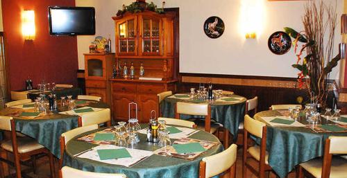 comedor con mesas y sillas y TV en Hostal La Barretina, en Figueres