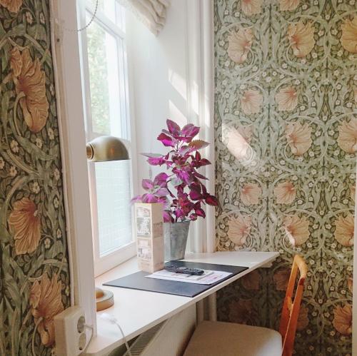 a room with a desk with a vase of flowers at Hotell Park in Västervik
