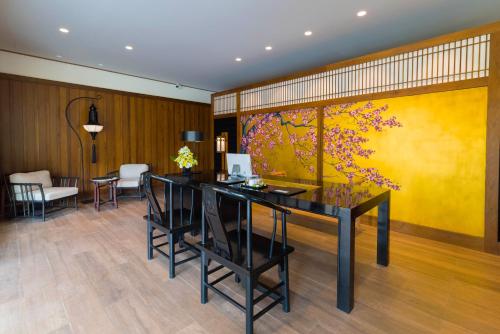 a dining room with a large painting on the wall at Onsen at Moncham in Mae Rim