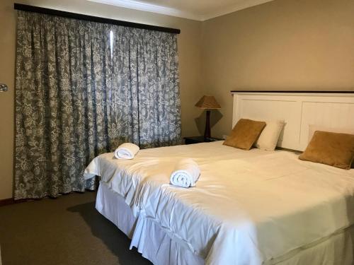 a bedroom with two beds with white towels on them at Windmill Farm in Bergville