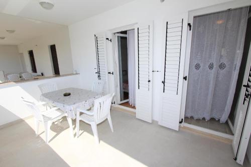 biała jadalnia z białym stołem i krzesłami w obiekcie Apartments Palaziol w Rovinj