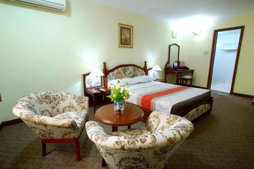 sypialnia z łóżkiem, 2 krzesłami i stołem w obiekcie Hoang Ha Hotel w Ho Chi Minh