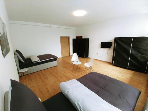 een slaapkamer met een bed, een bank en een tafel bij Pension BeOne in Trossingen