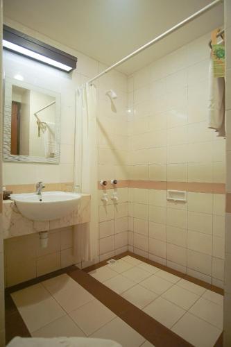 a bathroom with a sink and a shower at Sari Ater Hotel & Resort in Ciater