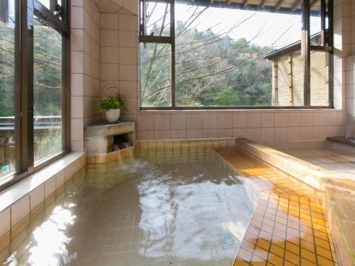 a pool of water in a room with windows at Ryori Ryokan Shikanoyu in Ena