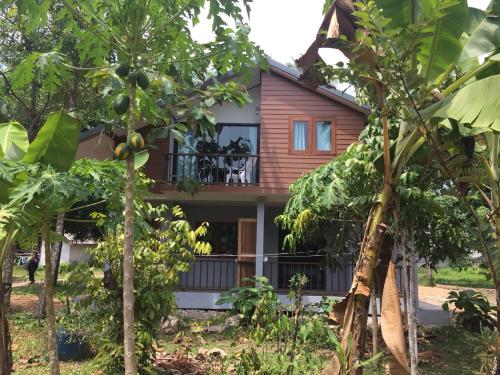 a house with a balcony in the middle of trees at Anattaya Holiday Home in Ko Yao Noi