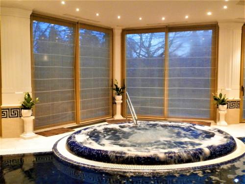 a large bathroom with a large tub in a room with windows at Nagyrét Panzió Eger in Eger