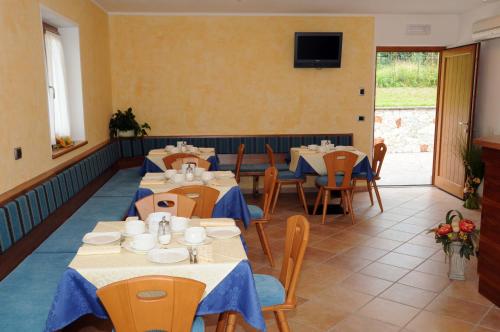 restauracja ze stołami i krzesłami oraz telewizorem na ścianie w obiekcie Agritur alla Veduta w Trydencie