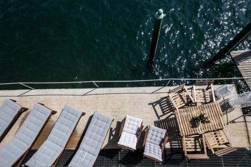 a group of chairs and tables next to the water at Darsena di Riva Grande in Moltrasio