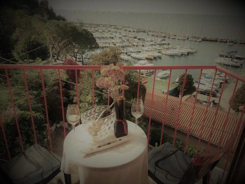 a table with wine glasses on a balcony with a harbor at Hotel Mignon in Trieste