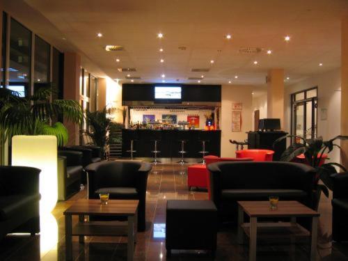a lobby with couches and tables and a bar at Grand Hotel Dream Main City Center in Frankfurt