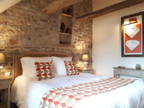 Mont-DolにあるJardin Des Simplesの石壁のベッドルーム1室(ベッド1台付)
