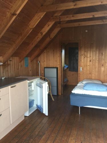ロッケンにあるLøkken Strand Campingの木製の部屋にベッド1台が備わるベッドルーム1室があります。