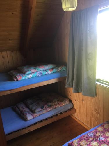 ロッケンにあるLøkken Strand Campingの窓付きのキャビン内の二段ベッド2台