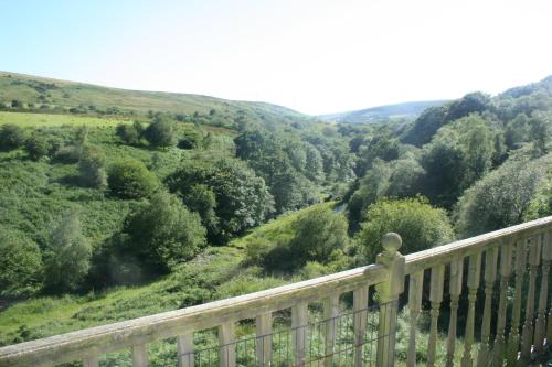 a wooden balcony with a view of a valley at Coynant Farm Guesthouse - Farm Park Stay in Swansea
