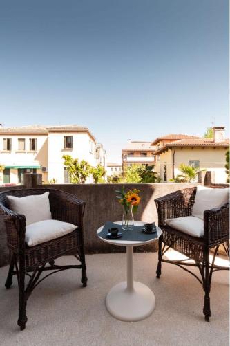 two chairs and a table with a vase of flowers on a patio at Esclusivo appartamento- 6 persone in Villa Liberty in Venice-Lido