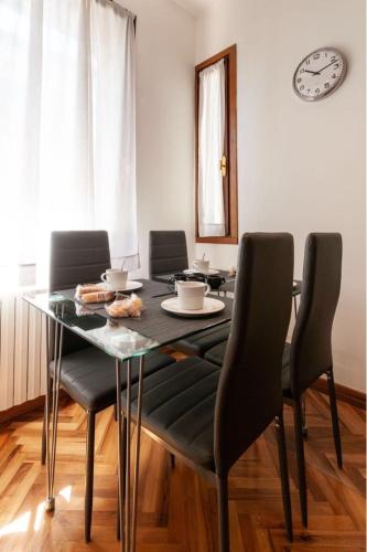 a dining room with a table and chairs and a clock at Esclusivo appartamento- 6 persone in Villa Liberty in Venice-Lido