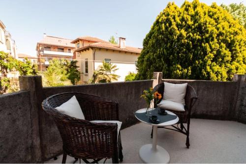 two wicker chairs and a table on a patio at Esclusivo appartamento- 6 persone in Villa Liberty in Venice-Lido