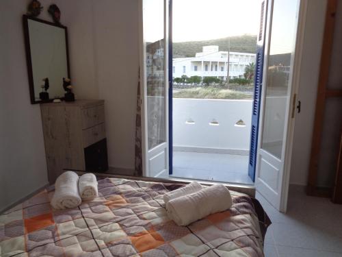 a bedroom with a bed with towels on it at Loutra House Kythnos in Loutra