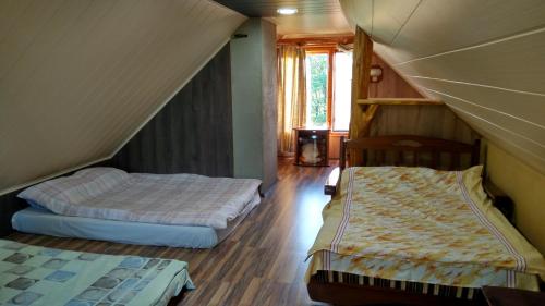 two beds in a room with a attic at Агроусадьба Кипшале in Vasyukovschina