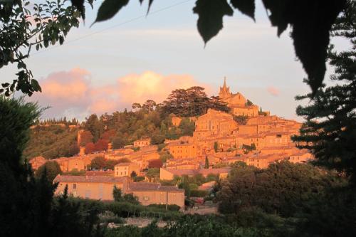 une ville sur une colline avec un château sur elle dans l'établissement L'Oustaou de Rose, à Bonnieux