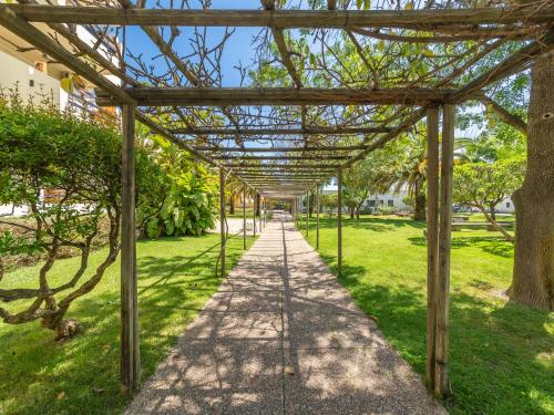 a pergola over a walkway in a park at Golden Club Cabanas in Cabanas de Tavira