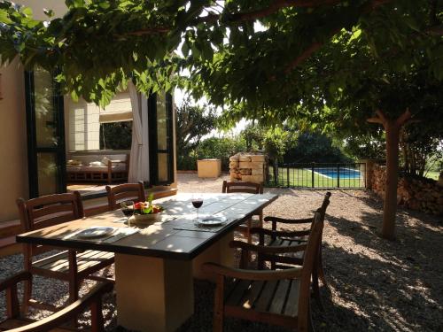 a table with a bowl of fruit and a glass of wine at Finca Son Blat in Porto Cristo